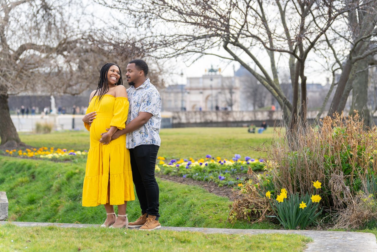 Couple in vibrant yellow dress at Jardin du Luxembourg with spring flowers and palace architecture in background
