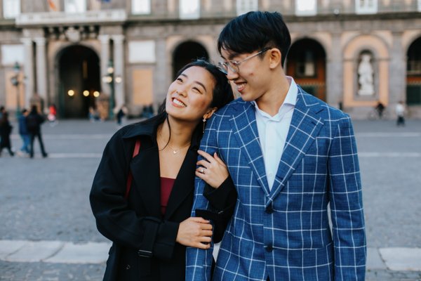 Couple smiling together in piazza del plebiscito, historic arched building in soft afternoon light