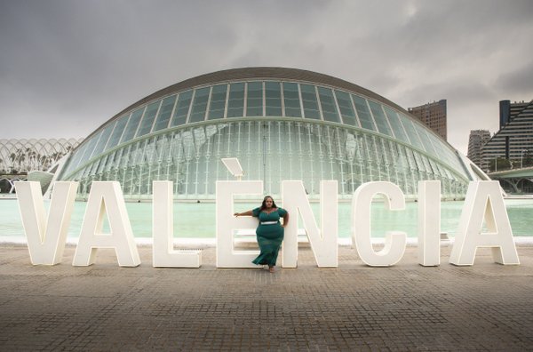 Solo traveler posing with Valencia letters at City of Arts and Sciences on overcast day