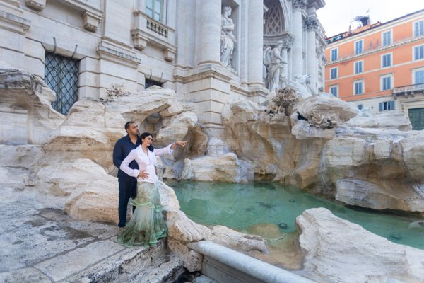 couple posing at turquoise waters of trevi fountain in rome during daytime