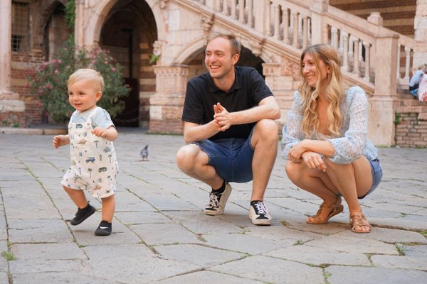 Family with toddler at historic Italian piazza with terracotta brick architecture in daylight
