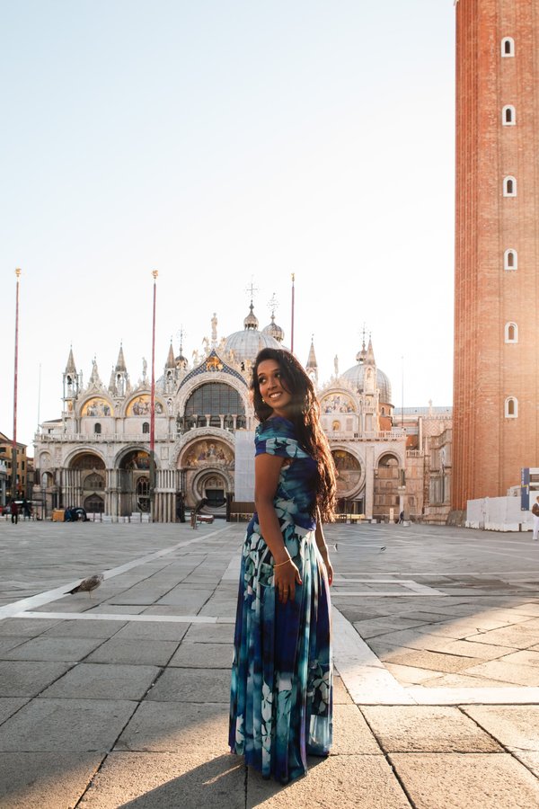 Solo traveler in blue patterned dress at St. Mark's Basilica in Venice during golden hour