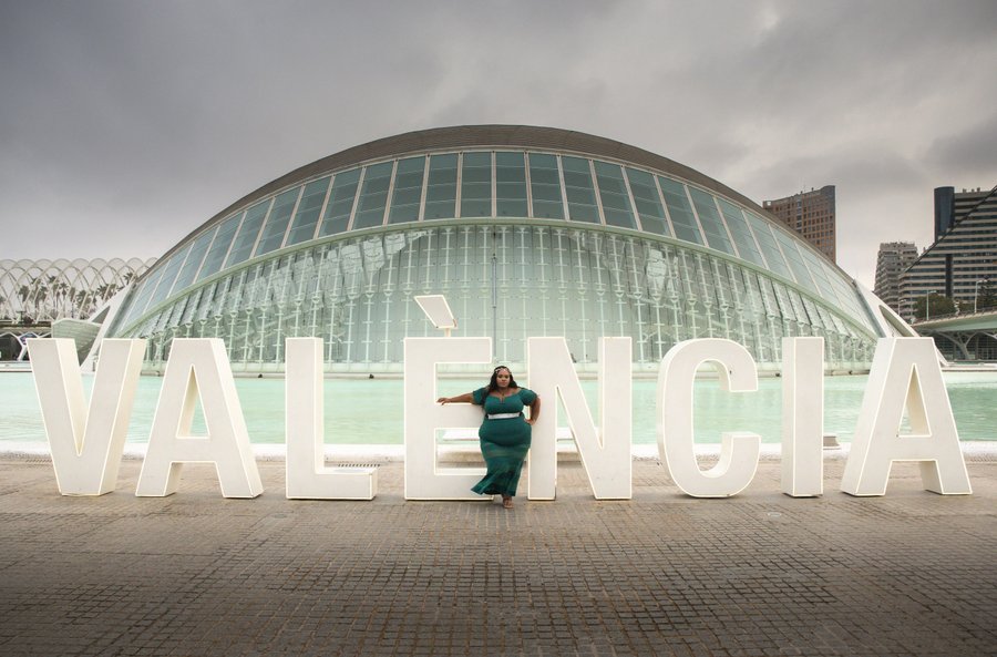 Solo traveler posing with Valencia letters at City of Arts and Sciences on overcast day