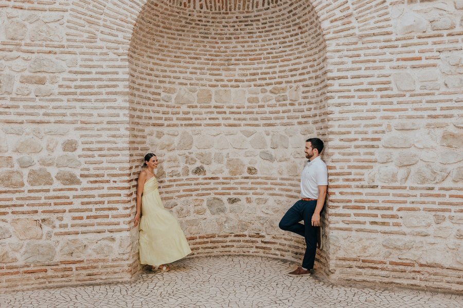 Couple posing inside the Roman Peristyle's arched brick chamber in Split during golden hour