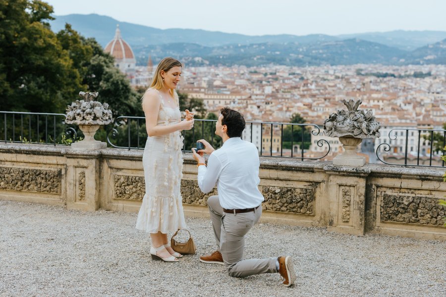 Man proposing to woman in white dress overlooking Florence and the Duomo at golden hour