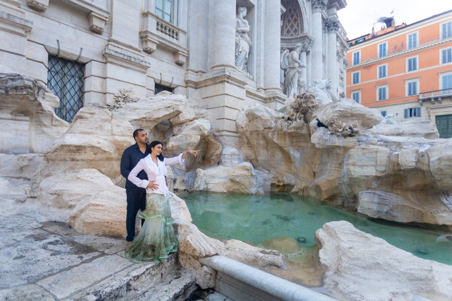couple posing at turquoise waters of trevi fountain in rome during daytime