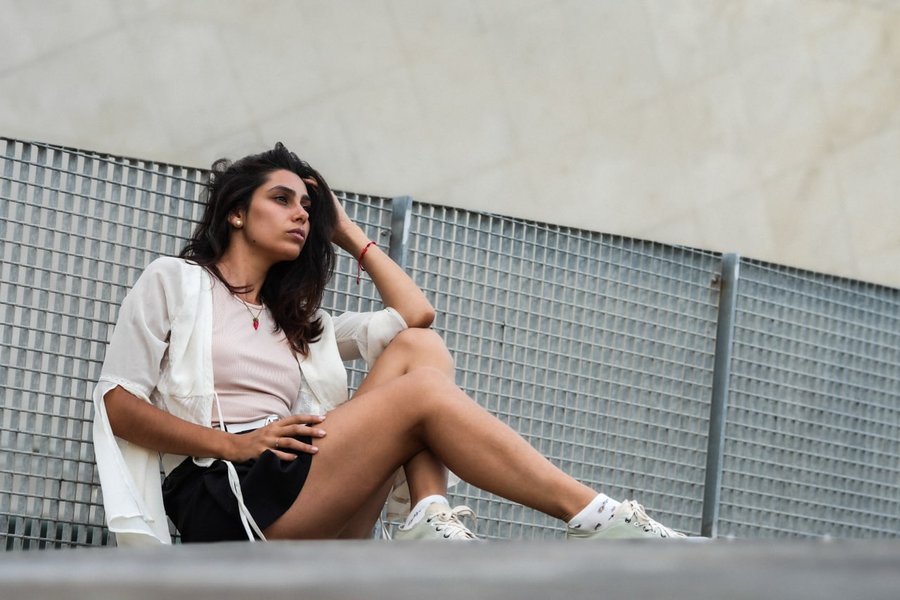 Solo traveler posing against modern metal fence in Porto during daytime
