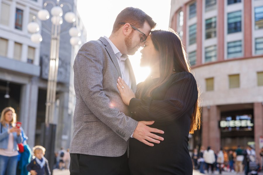 Couple embracing on a sunlit urban street in Milan during golden hour