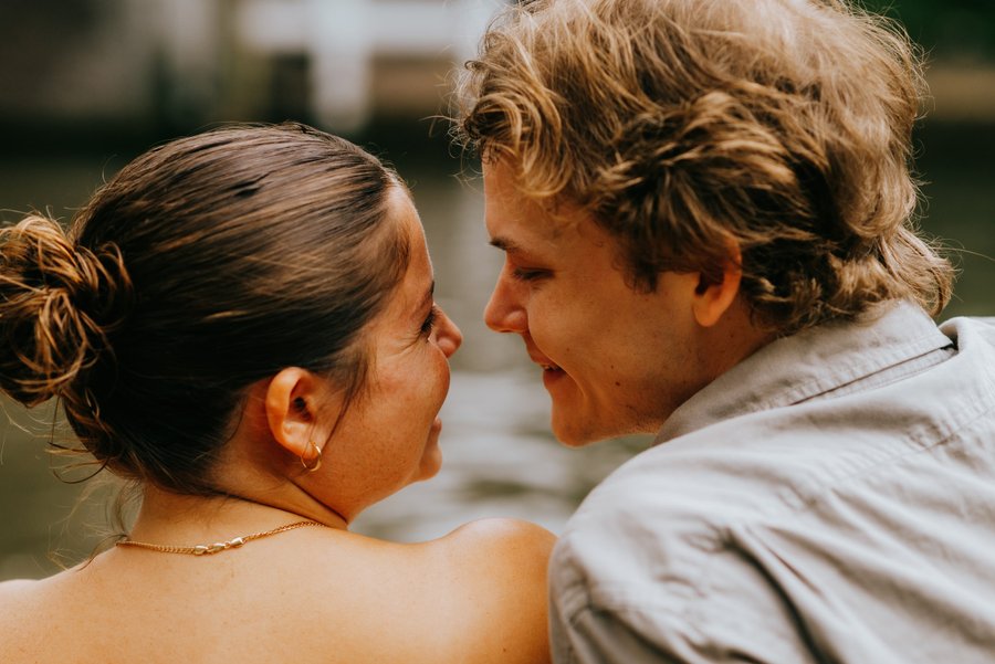 Couple facing each other in warm golden light at a historic Utrecht courtyard during daytime